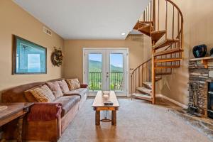 a living room with a couch and a spiral staircase at Rocky Top Oasis in Gatlinburg