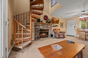 a living room with a staircase and a fireplace at Rocky Top Oasis in Gatlinburg +53 photos