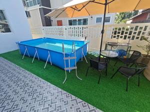 a pool table on a balcony with chairs and an umbrella at Chiangmai Love U Villas in Chiang Mai