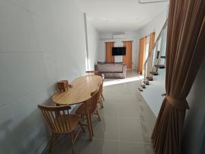 a dining room with a wooden table and chairs at Chiangmai Love U Villas in Chiang Mai