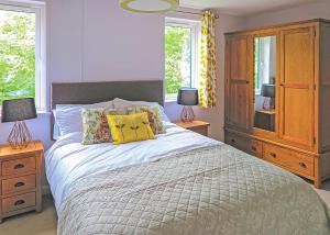 a bedroom with a bed with two lamps and a dresser at Kingswood Golf Lodges in Thorne