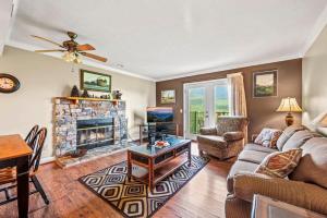 een woonkamer met een bank en een open haard bij Pinewood Escape in Gatlinburg