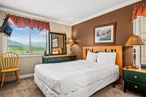 een slaapkamer met een bed, een stoel en een raam bij Pinewood Escape in Gatlinburg +25 foto's