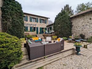 a backyard with a wooden deck with furniture at Ferme avec piscine couverte sur grand domaine - FR-1-582-515 in Saint-Romain-Lachalm