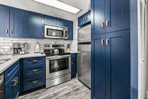 a kitchen with blue cabinets and stainless steel appliances at Hesed Mountain Haven in Gatlinburg