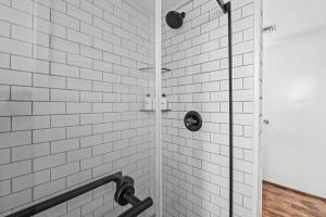 a white tiled shower with a glass door at Hesed Mountain Haven in Gatlinburg