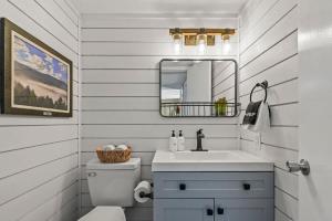 a white bathroom with a sink and a mirror at Hesed Mountain Haven in Gatlinburg +10 photos