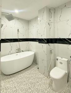 a bathroom with a white tub and a toilet at Thanh Binh Premium Hotel in Ho Chi Minh City