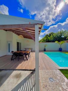 a patio with a table and a swimming pool at La Villa Harmonie in Sainte-Luce
