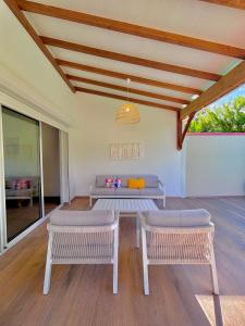 a living room with two benches and a table at La Villa Harmonie in Sainte-Luce