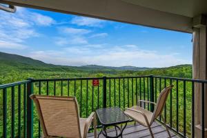 a balcony with chairs and a view of the mountains at Smoky Ridge Retreat in Gatlinburg