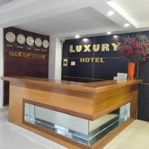 un vestíbulo de hotel con un mostrador y relojes en la pared en Luxury Hotel 1 HP- by BAY LUXURY, en Hai Phong