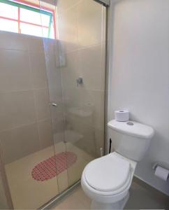 a bathroom with a toilet and a glass shower at Apartamento cómodo y tranquilo cerca al parque principal de Guatapé in Guatapé