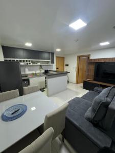 ein Wohnzimmer mit Tisch und Küche in der Unterkunft Apartamento charmoso e confortável no DF Century Plaza in Brasilia