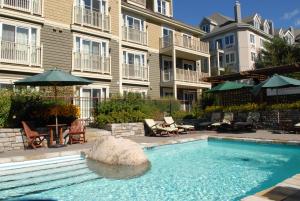 a swimming pool in front of a apartment building at Ermitage du Lac in Mont-Tremblant