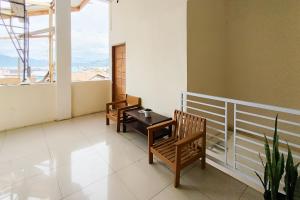 a balcony with two chairs and a table and a window at RedDoorz Syariah at Penginapan Berlian Takeengon in Takengon