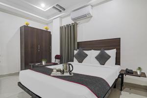 a bedroom with a large bed and a desk at FabHotel White House Leo in Kondapur +46 photos