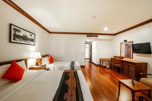 a hotel room with two beds and a television at Royal Crown Hotel & Spa in Siem Reap