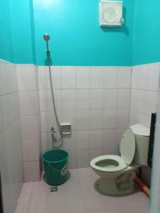 uma casa de banho com um WC e um balde verde em CCMPC room for rent em San Juan
