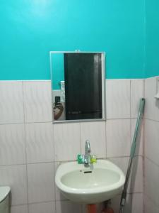 um banheiro com uma pia e um espelho em CCMPC room for rent em San Juan
