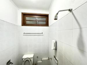 TimuranHotel Dewi Sri Prawirotaman RedPartner的带马桶和窗户的白色浴室 更多32张照片