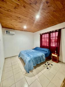 a bedroom with a blue bed and a wooden ceiling at Departamento Paulina,Ubicado en lugar privilegiado de la Ciudad in Federación