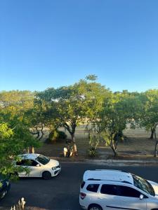 two white cars parked in a parking lot with trees at Departamento Paulina,Ubicado en lugar privilegiado de la Ciudad in Federación