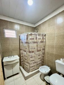 a bathroom with a shower curtain and a toilet at Departamento Paulina,Ubicado en lugar privilegiado de la Ciudad in Federación