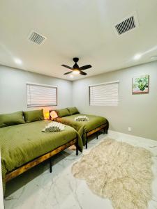 un soggiorno con 2 letti e un ventilatore a soffitto di Tropical Luxury Paradise - Fully Renovated in WPB a West Palm Beach Altre 174 foto
