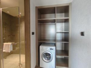 a bathroom with a washing machine in a closet at Somerset Xuhui Riverside Shanghai serviced apartments in Shanghai