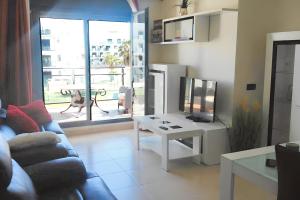 salon z kanapą i stołem z telewizorem w obiekcie Comfortable Apartment in Almería with Shared Pool - 72 m² w mieście Retamar