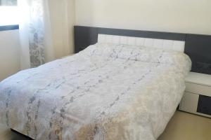 sypialnia z łóżkiem z białą kołdrą w obiekcie Comfortable Apartment in Almería with Shared Pool - 72 m² w mieście Retamar
