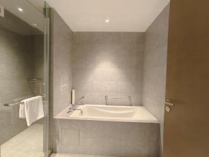a bathroom with a bath tub and a sink at Somerset Xuhui Riverside Shanghai serviced apartments in Shanghai