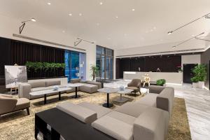 a lobby with couches and tables in a building at Somerset Xuhui Riverside Shanghai serviced apartments in Shanghai