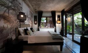 a bedroom with a bed and a large window at La Plage Hotel in El Nido +34 photos