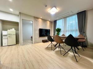a living room with a table and chairs and a television at Eunhasu D&M Residence in Daejeon