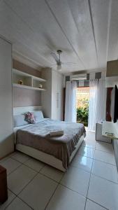 a bedroom with a large bed and a large window at Suítes Canto do Pontal in Paraty