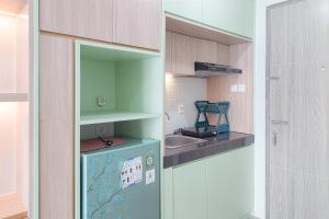 una piccola cucina con frigorifero e lavandino di Homey and Comfort Stay Studio Apartment at Anwa Residence By Travelio a Tangerang