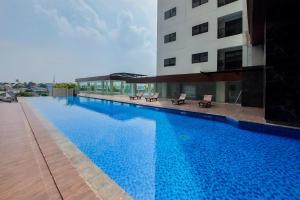 una grande piscina accanto a un edificio di Homey and Comfort Stay Studio Apartment at Anwa Residence By Travelio a Tangerang