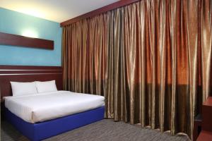 een slaapkamer met een bed en een gordijn bij D'Merlion Hotel in Bagam