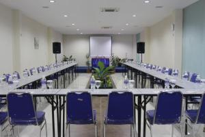 een vergaderzaal met tafels en blauwe stoelen bij D'Merlion Hotel in Bagam