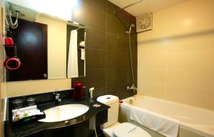 a bathroom with a sink and a toilet and a tub at Serene Shining Hotel & Spa in Hue