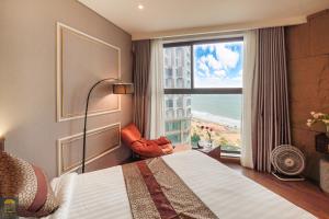 ein Hotelzimmer mit einem Bett und einem großen Fenster in der Unterkunft Apec Beach Mui Ne Resort in Mui Ne