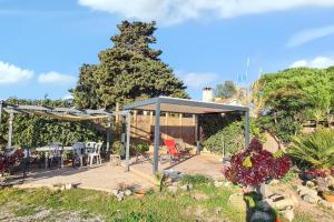 une terrasse en bois avec des chaises et des tables dans un jardin dans l'établissement Studio charmant à Hyères avec barbecue - 22 m², à Hyères 8 autres photos