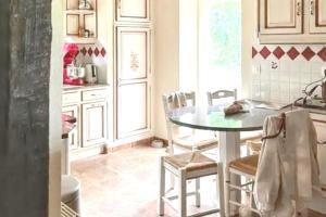 a kitchen with a table and chairs in a room at Maison normande apaisante à Hermival-les-Vaux avec sauna in Hermival-les-Vaux