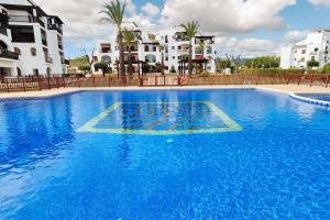 a large blue swimming pool with buildings in the background at Spacious apartment with pool in the heart of Murcia - 128 m² in Murcia