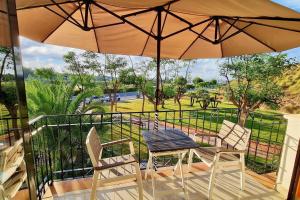 a table and chairs on a balcony with an umbrella at Spacious apartment with pool in the heart of Murcia - 128 m² in Murcia