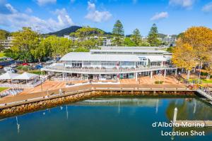 an aerial view of a building next to a body of water at Bayside 6, 21 Victoria Pde - sensational water views, linen in Nelson Bay