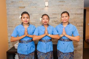 Três raparigas de uniforme azul estão a fazer uma orativorativorativelicationlicationlicationlicationlication em Spa Hotel Calista em Starozagorski Bani