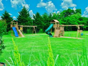 two playground equipment in a grassy field at A Beary Good Getaway condo in Pigeon Forge